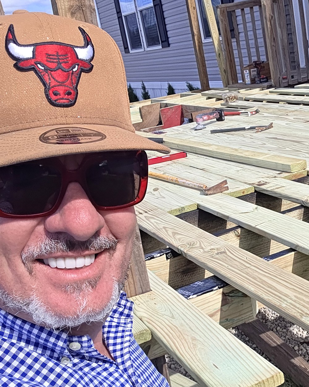 David Gilley, owner of Red Star Luxury Homes, smiling in a tan cap and blue gingham shirt