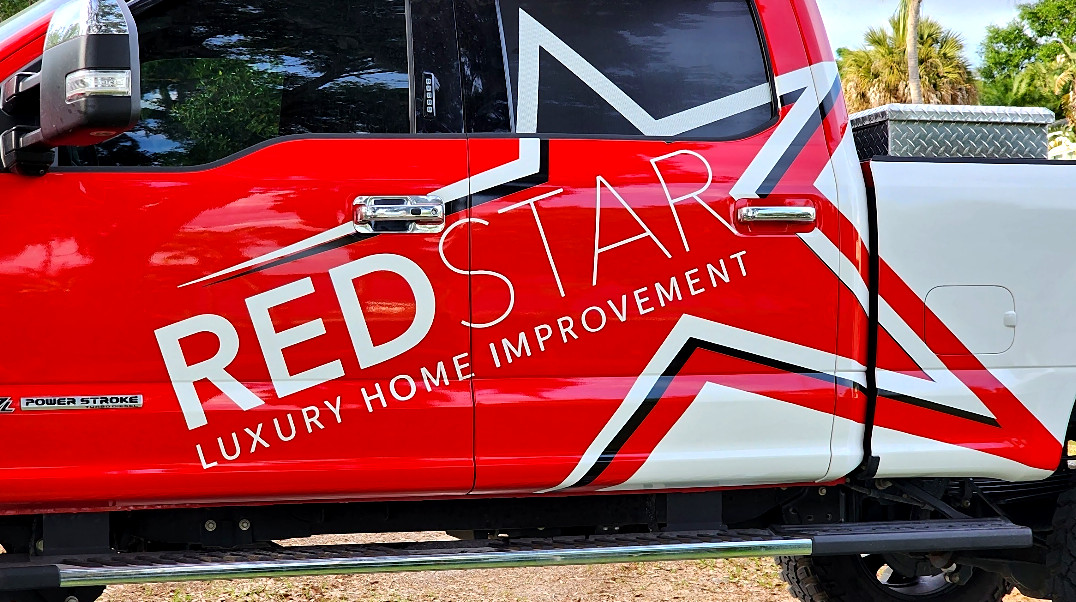 Red Star Luxury Home Improvement logo on the door of a red company truck